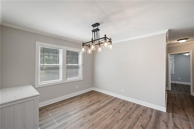 unfurnished dining area with ornamental molding, hardwood / wood-style flooring, and an inviting chandelier