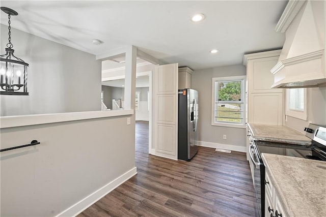 kitchen with appliances with stainless steel finishes, custom range hood, dark wood-type flooring, decorative light fixtures, and a notable chandelier