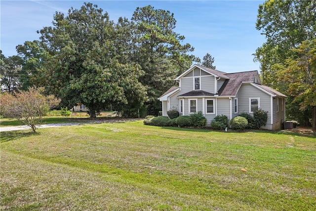 view of front of home with a front lawn and central AC