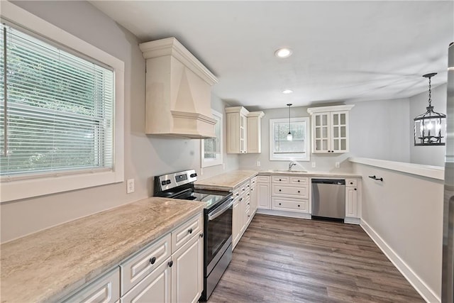 kitchen with decorative light fixtures, appliances with stainless steel finishes, and a healthy amount of sunlight