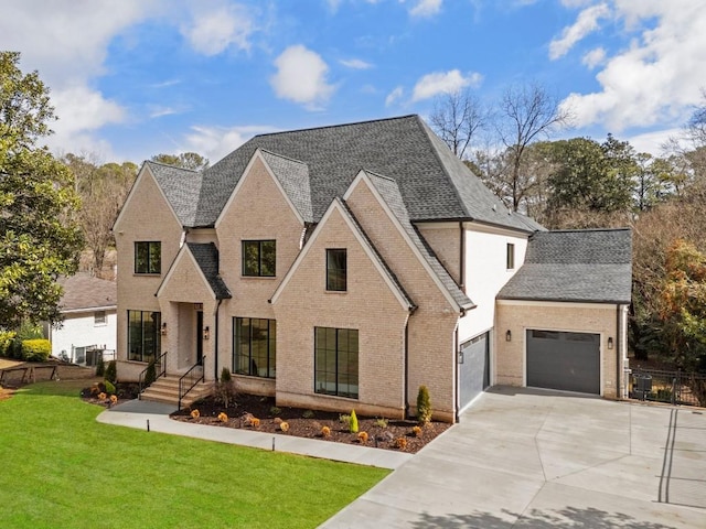 view of front of house with an attached garage, concrete driveway, brick siding, and a front yard