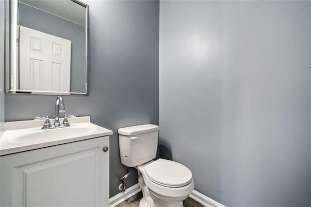 bathroom featuring vanity, hardwood / wood-style flooring, and toilet