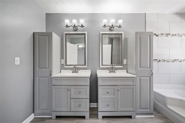 bathroom featuring vanity, a washtub, and a textured ceiling