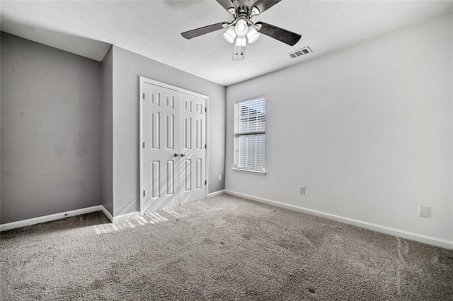 unfurnished bedroom with carpet floors, a closet, and ceiling fan