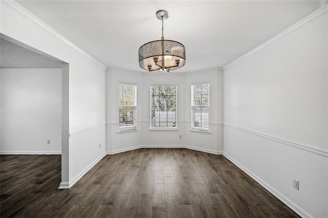 unfurnished dining area featuring dark wood-type flooring, crown molding, and an inviting chandelier