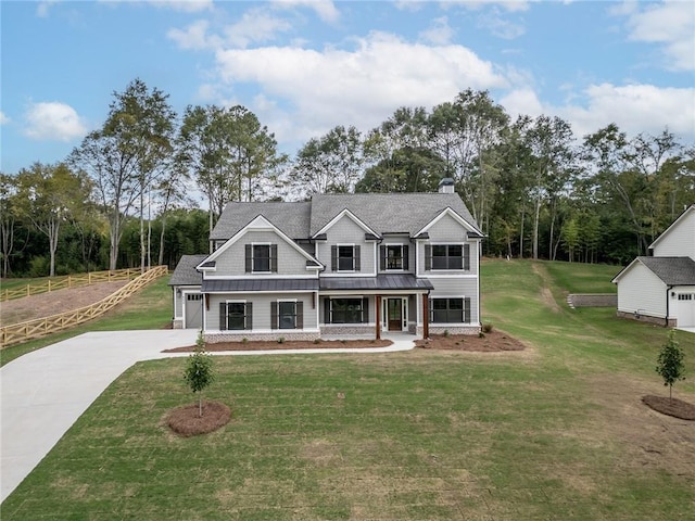 view of front of property featuring a garage, covered porch, and a front lawn