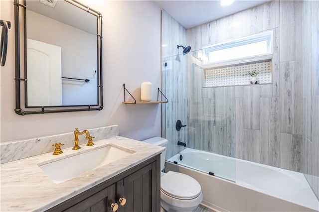 full bathroom with vanity, tiled shower / bath combo, and toilet