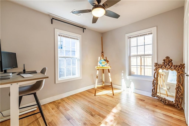 office area featuring light hardwood / wood-style flooring, ceiling fan, and a healthy amount of sunlight