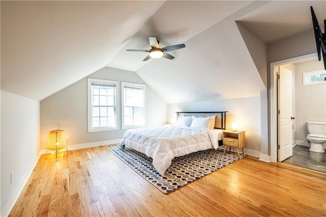 bedroom with ensuite bath, ceiling fan, wood-type flooring, and lofted ceiling