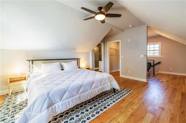 bedroom featuring a spacious closet, a closet, ceiling fan, and vaulted ceiling