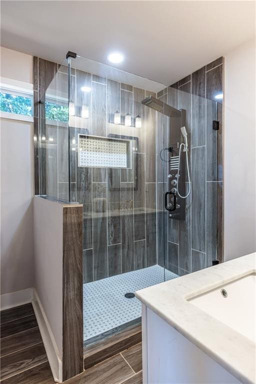 bathroom with a tile shower and vanity