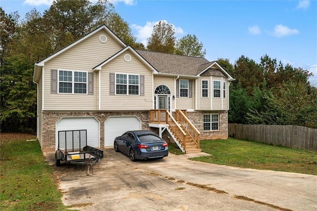 raised ranch featuring a front lawn and a garage