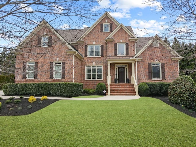 view of front of house with brick siding and a front lawn