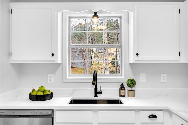 kitchen with dishwasher, light countertops, a sink, and white cabinets