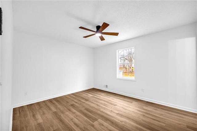 unfurnished room with light wood-type flooring, visible vents, ceiling fan, and baseboards