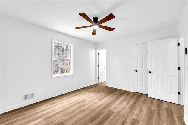 unfurnished bedroom featuring visible vents, ceiling fan, light wood-style flooring, and baseboards