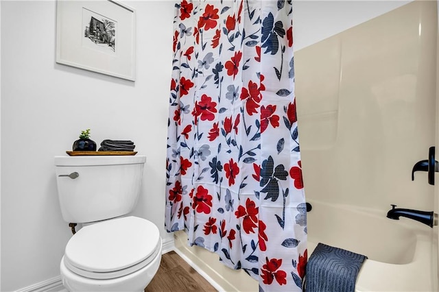 full bathroom with baseboards, toilet, and wood finished floors