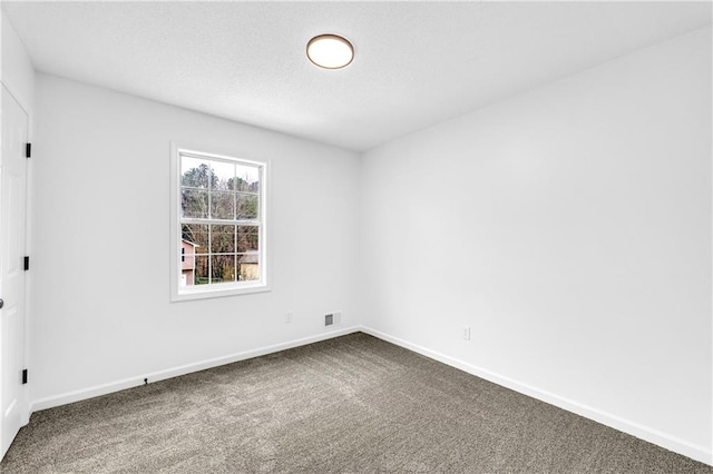 carpeted empty room featuring baseboards and visible vents