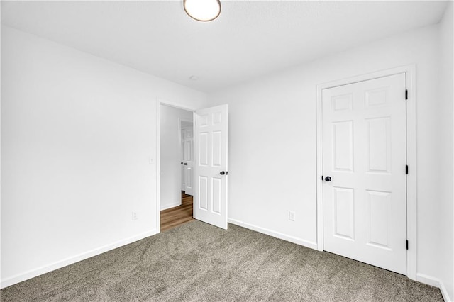 unfurnished bedroom featuring carpet and baseboards