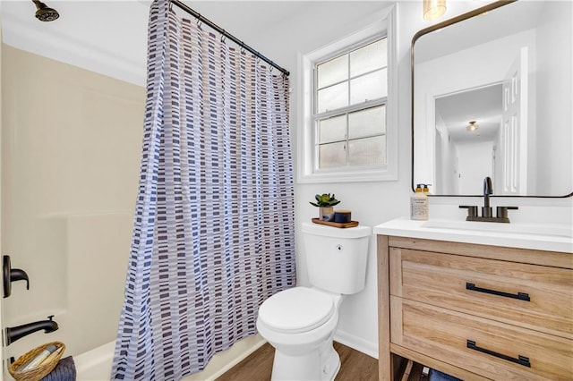 bathroom with toilet, wood finished floors, shower / bath combo with shower curtain, and vanity