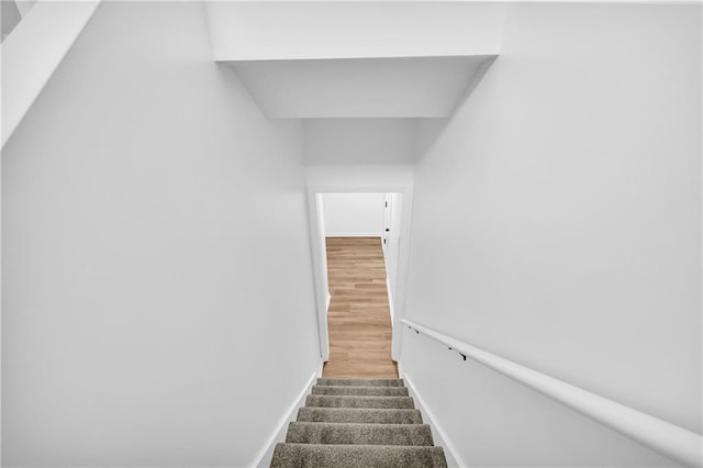 stairway featuring wood finished floors and baseboards