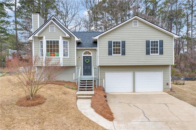 bi-level home with a garage, driveway, a shingled roof, and a chimney