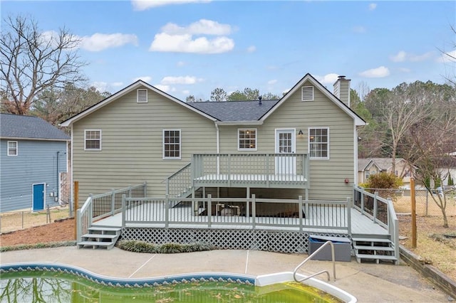 back of house with a patio, a chimney, a fenced in pool, and a wooden deck