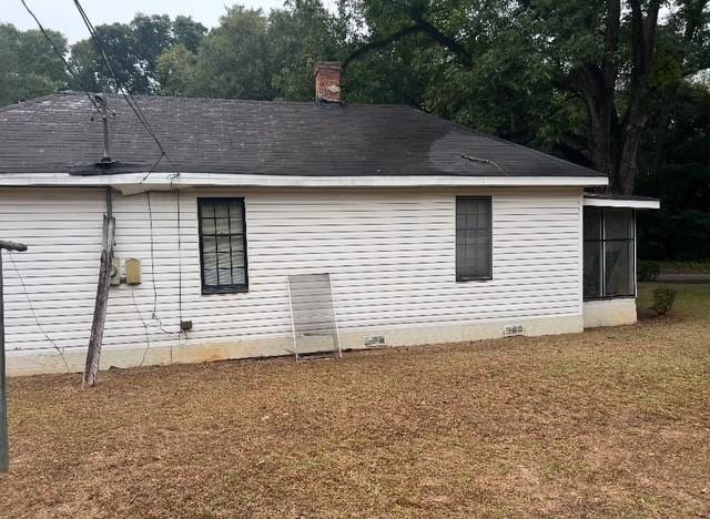 view of side of property with a chimney and crawl space