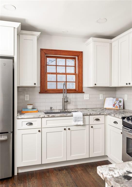 kitchen featuring stainless steel appliances, tasteful backsplash, and white cabinets