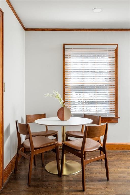 dining area featuring baseboards, ornamental molding, and wood finished floors