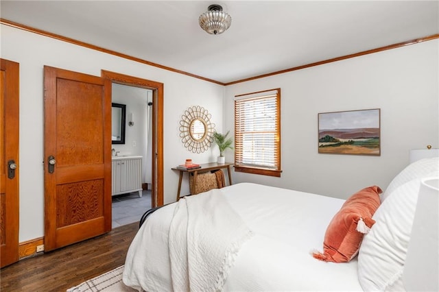 bedroom with ornamental molding, wood finished floors, and ensuite bathroom