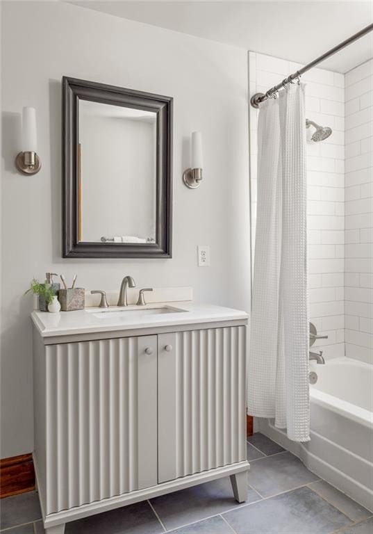 full bath with tile patterned flooring, shower / bath combination with curtain, vanity, and baseboards