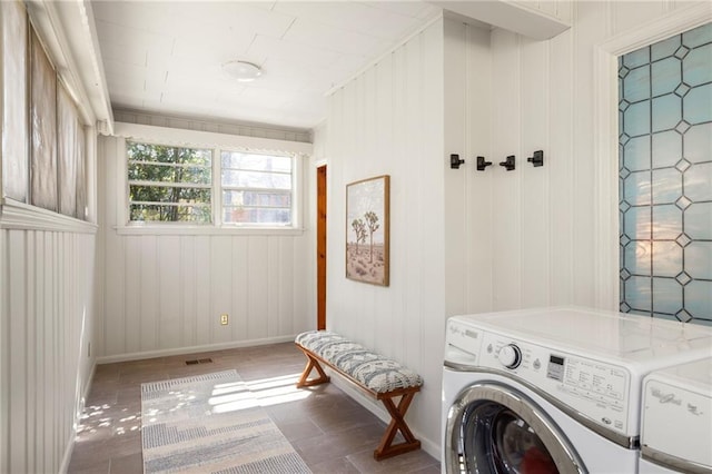 laundry area with laundry area, washing machine and dryer, visible vents, and baseboards