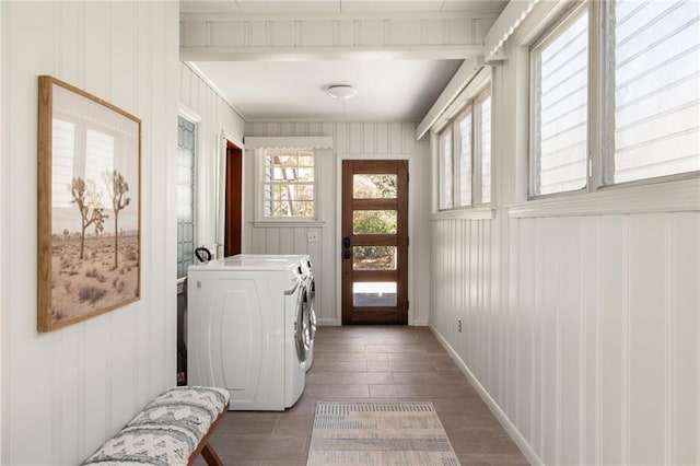 washroom featuring laundry area, baseboards, and separate washer and dryer