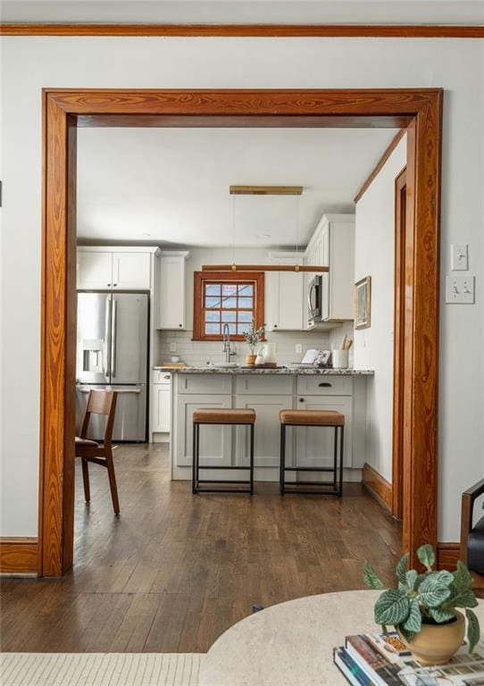 kitchen with white cabinetry, appliances with stainless steel finishes, dark wood finished floors, and a sink