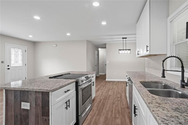 2478 Graywall St, East Point, GA 30344 - kitchen featuring appliances with stainless steel finishes, a sink, baseboards, light wood finished floors, and white cabinets