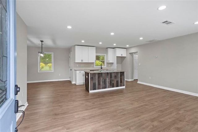 2478 Graywall St, East Point, GA 30344 - kitchen with white cabinetry, open floor plan, a center island, baseboards, and wood finished floors