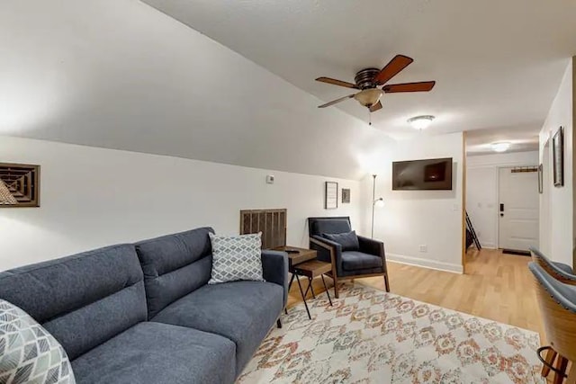 living room featuring light wood-type flooring, vaulted ceiling, and ceiling fan