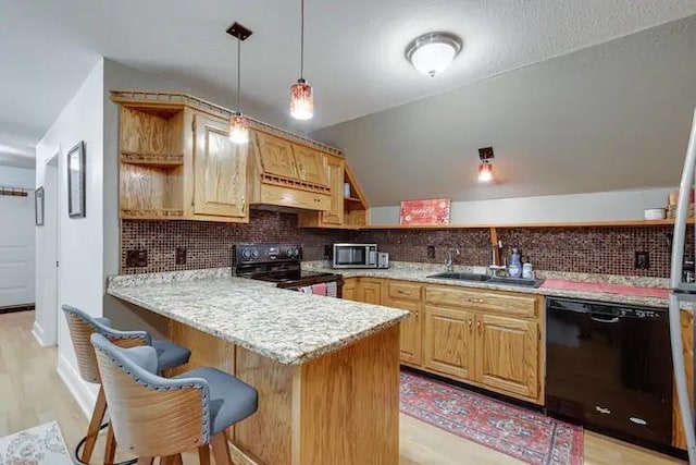 kitchen featuring kitchen peninsula, decorative backsplash, black appliances, pendant lighting, and a breakfast bar area