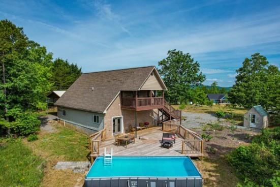 rear view of property featuring a swimming pool side deck