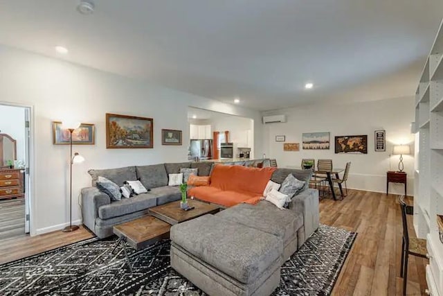 living room with wood-type flooring and a wall mounted AC