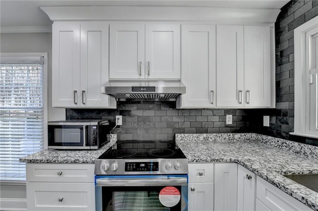 kitchen with extractor fan, appliances with stainless steel finishes, ornamental molding, and white cabinetry