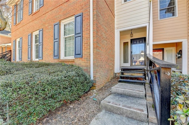 entrance to property featuring brick siding