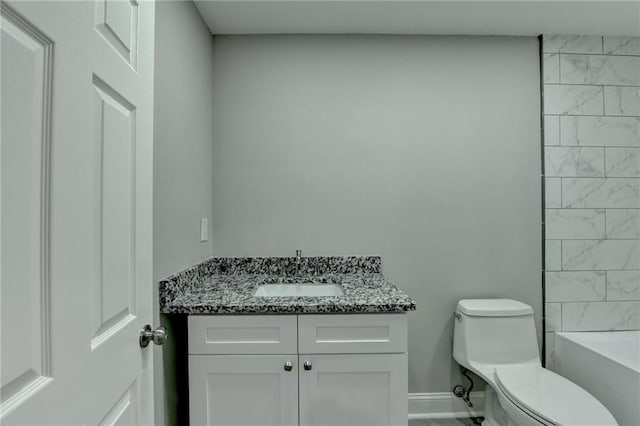 bathroom featuring vanity, toilet, and baseboards