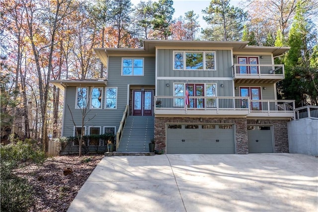 view of front of house featuring concrete driveway, stone siding, and an attached garage