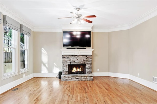 unfurnished living room featuring a stone fireplace, wood finished floors, visible vents, and crown molding