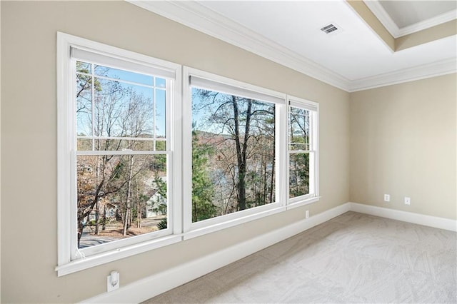 spare room featuring baseboards, ornamental molding, visible vents, and light colored carpet