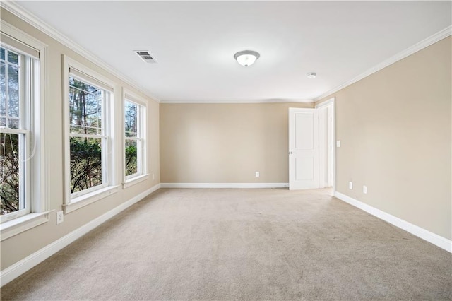 carpeted spare room featuring baseboards, visible vents, and crown molding