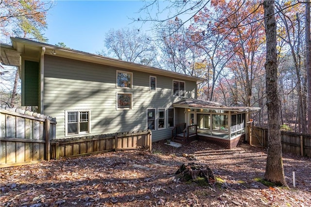 back of house with a sunroom and a fenced backyard