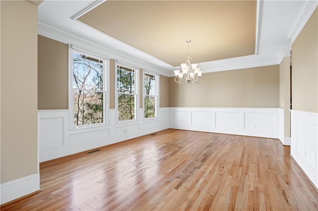 unfurnished dining area with light wood-style flooring, visible vents, and ornamental molding